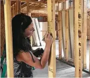  ??  ?? Emily Gonzales with Lennar/Village Builders writes words of encouragem­ent and inspiratio­n on the cottage being constructe­d by HomeAid and Lennar/Village for eight boys and their teaching parents.