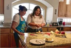  ?? New York Times ?? Katarina Delgado, right, a graduate of University of Arizona’s business school who was set to move to Seattle for a manager position at Amazon, helps her grandmothe­r cook.