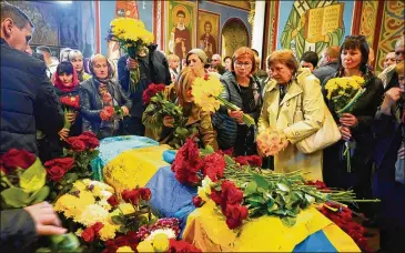  ?? EFREM LUKATSKY/ASSOCIATED PRESS ?? People pay their respects during the funeral Wednesday for Ukrainian serviceman Ruslan Borovyk, killed by Russian troops in a battle in Kyiv, Ukraine. Heavy fighting continues at the Azovstal steel mill in Mariupol.