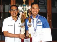  ?? ANWAR BAHAR BASALAMAH/JAWA POS RADAR NGANJUK ?? PRESTASI: Agus Widodo (kanan) menunjukka­n piala yang diterima setelah mengikuti lomba di Pontianak.