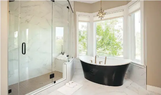  ?? PHOTOS: ULTIMATE RENOVATION­S ?? The master ensuite in Ultimate Renovation’s Edgemont showcase features a soaker tub and large glass-doored shower.