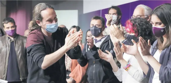  ??  ?? Pablo Iglesias rodeado de compañeros del partido, durante una conferenci­a de prensa tras las elecciones en la Comunidad de Madrid, el martes pasado.