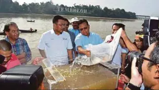  ??  ?? AHMAD Shabery melepaskan 54,321 ikan pelbagai spesies di Sungai Pahang.