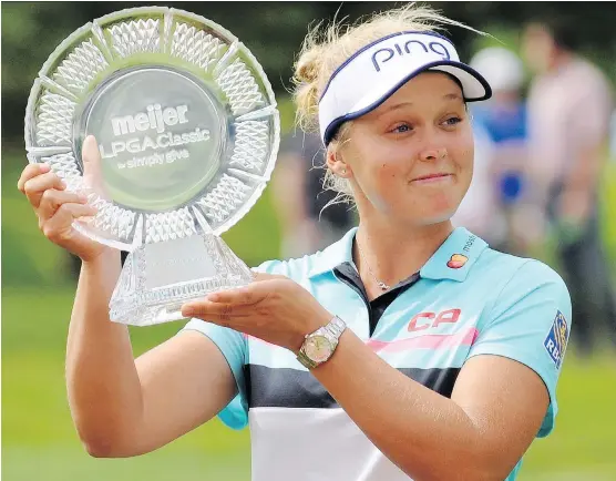  ?? CORY OLSEN/THE ASSOCIATED PRESS ?? Brooke Henderson with the winner’s trophy after winning the Meijer LPGA Classic by two strokes Sunday at Blythefiel­d Country Club in Grand Rapids, Mich.