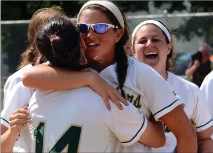  ?? MEDIANEWS GROUP FILE PHOTO ?? Lansdale Catholic pitcher Ashley Seal is embraced by Kristin Szczepania­k (14) and teammates as they celebrate their 2-1victory over Berwick in their playoff contest at Patriots Park in Allentown.