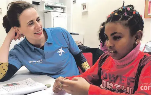  ??  ?? Una voluntaria de CaixaBank colabora en una actividad infantil durante la Semana Social que organiza la entidad