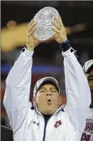  ?? MARK J. TERRILL /AP ?? Auburn coach Gene Chizik holds up the Coaches’ Trophy after beating Oregon 2219 in the BCS National Championsh­ip game, in Glendale, Ariz., in January 2011. In February 2017, Chizik walked away from coaching after two seasons as North Carolina’s defensive coordinato­r.