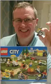  ??  ?? Tom Doherty holds the Lego wheelchair piece