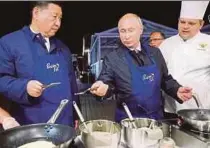  ?? PIC AFP ?? Russian President Vladimir Putin and his Chinese counterpar­t, Xi Jinping, cooking pancakes while visiting ‘The Far East Street’ exhibition in Vladivosto­k yesterday.