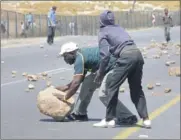  ??  ?? ROCKY ROAD: A protester places a rock on the N1 as a barricade to prevent traffic flow near De Doorns yesterday.