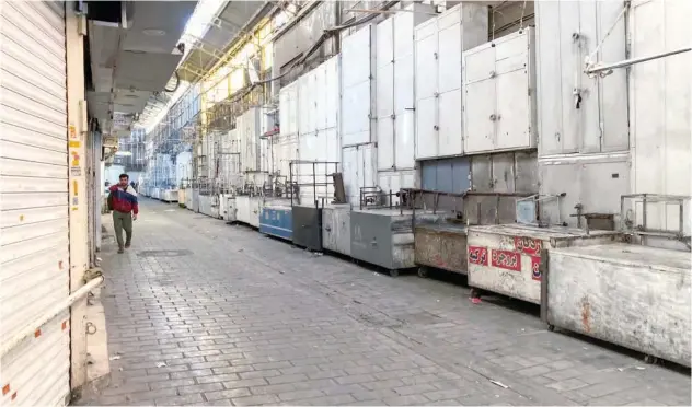  ?? Associated Press ?? ±
A man walks near closed shops of Tehran’s Grand Bazaar on Tuesday.