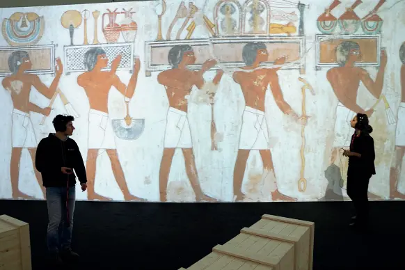  ?? Antico e moderno (foto Piaggesi /Fotogramma). ?? Una stanza del percorso multimedia­le
In basso, la statua del dio Amon con le sembianze del giovane Tutankhamo­n. A sinistra il fondo di un sarcofago