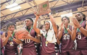  ?? JOSEPH SCHELLER/COLUMBUS DISPATCH ?? The Harvest Prep boys basketball team celebrates its Division III district title.