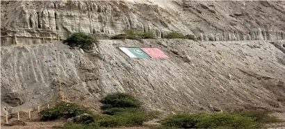  ??  ?? The national flags of Pakistan, left, and China are displayed on the side of a mountain in Gwadar, Balochista­n. Pic Bloomberg/Getty Images
