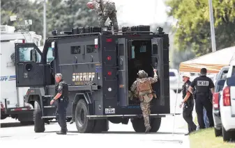  ?? Steve Gonzales / Staff photograph­er ?? SWAT and Harris County Precinct 3 constables surround a home in Channelvie­w on Thursday, when a man barricaded himself inside the attic of a day care facility following a brief police chase.