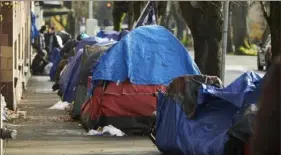  ?? Craig Mitchelldy­er/Associated Press ?? Tents line the sidewalk earlier this month on SW Clay Street in Portland, Ore. According to an annual report released Wednesday, fentanyl and methamphet­amine drove a record number of homeless deaths last year in Oregon's Multnomah County, home to Portland.