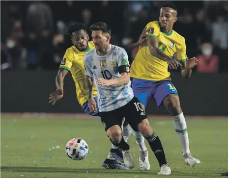  ?? AFP ?? Lionel Messi goes past Fred and Eder Militao in Tuesday night’s draw with Brazil that secured Argentina’s spot at Qatar 2022