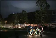  ?? JAE C. HONG - THE ASSOCIATED PRESS ?? Two children pose for photos with the Olympic Rings in front of New National Stadium in Tokyo, June 23, 2019.