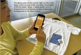  ?? Japan News-Yomiuri ?? The device seen on the pocket, right, on this e-skin Sleep T-shirt records health and other informatio­n while the wearer sleeps. A sleep-quality score is displayed on a smartphone, as seen at Xenoma’s headquarte­rs in Ota Ward, Tokyo.