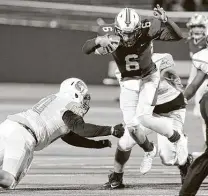  ??  ?? Brackenrid­ge QB Carlos Camargo (6) leaps to avoid Sam Houston's Danny Micelles (60) during the Eagles' 26-20 win.