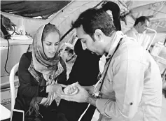  ??  ?? Iranian medics tend to quake victims and survivors at a field hospital in the town of Sarpol-e Zahab in the western Kermanshah province. — AFP photo