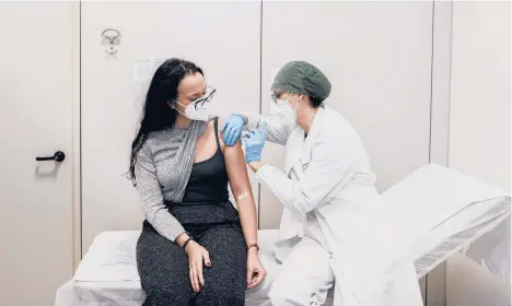  ?? ALESSANDRO GRASSANI/THE NEW YORK TIMES ?? A woman receives a vaccine for COVID-19 Dec. 27 at a hospital in Piacenza, Italy.