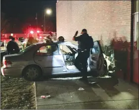  ?? (NWA Democrat-Gazette/Graham Thomas) ?? Emergency personnel work at the scene of a motor vehicle accident at Siloam Springs Intermedia­te School. The vehicle crashed into the building near to the site of a previous accident in which a motorist crashed into the school building.