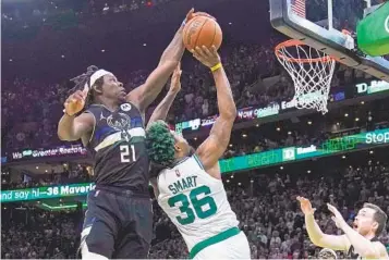  ?? CHARLES KRUPA AP ?? Milwaukee’s Jrue Holiday blocks a shot by Boston’s Marcus Smart in the game’s final seconds.