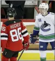  ?? FRANK FRANKLIN II — THE ASSOCIATED PRESS ?? Vancouver’s Quinn Hughes, right, talks to his brother Jack Hughes, left, before Saturday’s game against the Devils in Newark, N.J. The Devils won 1-0.