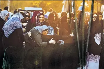  ?? Gina Ferazzi Los Angeles Times By Alex Wiggleswor­th ?? RELATIVES console one another during the burial of Joseph Awaida, 30, his wife, Raihan, 32, and their son, Omar, 3, at Westminste­r Memorial Park. The three were hit by a suspected DUI driver on Halloween night.