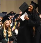  ?? RECORDER PHOTO BY CHIEKO HARA ?? Valedictor­ians Andrea Murguia, left, and Vanessa Ramos congratula­te each other while taking turns giving speeches Thursday during the Harmony Magnet Academy graduation ceremony at the Frank “Buck” Shaffer Theater inside of the Portervill­e Memorial...