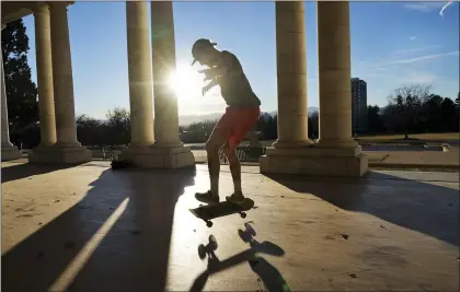  ?? BRITTANY PETERSON — THE ASSOCIATED PRESS ?? Drew Darnell rides his skateboard at Cheesman Park Pavilion on Wednesday in Denver. The city is close to breaking a record for its longest streak ever without snow.