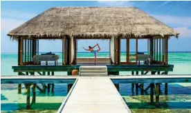  ??  ?? BALANCING ACT: A visitor practises yoga at the Rangali Island resort