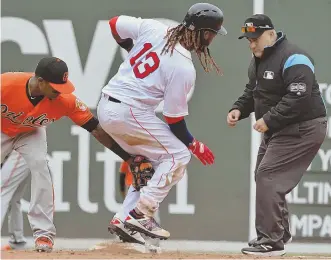  ?? STAFF PHOTO BY CHRIS CHRISTO ?? EVERYTHING’S CLICKING: Hanley Ramirez (above) slides into second base on a double in the fourth inning, and reliever Marcus Walden (right) gets a hug from Sandy Leon after the Red Sox’ 10-3 rout of the Orioles yesterday at Fenway Park.