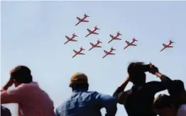  ?? — PTI ?? People look on as Hawk Mk- 132 Advanced Jet Trainers of the IAF’s Surya Kiran team rehearse for a fly- past ahead of the 12th edition of Aero India 2019 at Yelahanka Air Base in Bengaluru on Sunday.