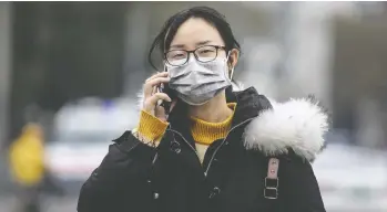  ?? GETTY IMAGES ?? A woman wears a mask Friday while walking past the closed Huanan Seafood Wholesale Market, which has been
linked to cases of coronaviru­s, in Wuhan, Hubei province, China. The mysterious virus has claimed two lives.