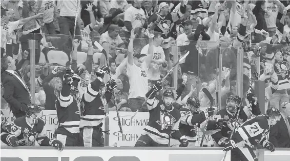  ??  ?? Penguins fans and bench celebrate Chris Kunitz’s series winning goal during the second overtime period of Game 7 in Pittsburgh Thursday night.