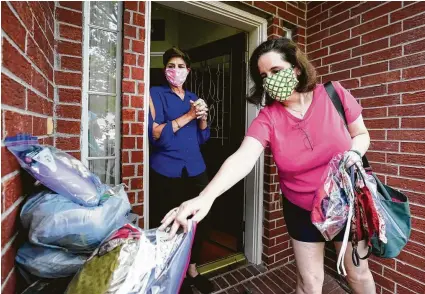  ?? Melissa Phillip / Staff photograph­er ?? Dawn Champagne, left, and Carrie Zamora are part of a group of women who make masks. The Mighty Mask Makers of Katy have sewn and distribute­d over 1,200 masks. Fabric masks will be required in public beginning Monday.