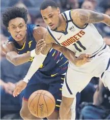  ??  ?? The Nuggets’ Monte Morris, right, battles the Cavaliers’ Collin Sexton for a loose ball Saturday night in Cleveland.