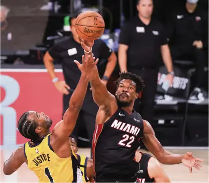  ?? MIKE ERHMANN AP ?? Jimmy Butler vies for possession with Indiana’s T.J. Warren during the Heat’s win in the series opener Tuesday. Butler was the driving force in his Heat playoff debut with a game-high 28 points. The All-Star wing was true to his reputation of raising his game in the playoffs.