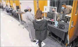  ?? K.M. Cannon Las Vegas Review-journal @Kmcannonph­oto ?? Nevada National Guard specialist­s Alondra Felix and Daniel Merchant check in with Ana Pena, left, and Karina Lewis during COVID-19 testing at UNLV on Monday.