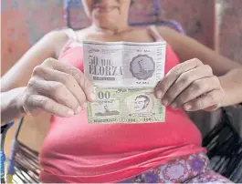  ?? REUTERS ?? A woman shows Elorza banknotes at her home in Elorza, Venezuela on Monday.