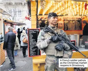  ??  ?? A French soldier patrols as the Christmas market reopens in Strasbourg