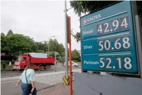  ??  ?? AP PHOTO BY BULLIT MARQUEZ A commuter walks past a huge sign of the new pump prices of gasoline and diesel following its implementa­tion Tuesday, Sept. 17, in suburban Valenzuela city north of Manila, Philippine­s. Monday saw another round of oil price increase in the country which energy officials said is not related to the recent attacks in Saudi Arabia but has cautioned the public to brace for more spikes in the coming days.