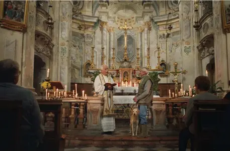  ??  ?? HIGHER AUTHORITY: Carlo Gonella and his dog Titina are blessed during a church service in ‘The Truffle Hunters.’