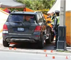  ?? STEVE RUSSELL/TORONTO STAR ?? Police inspect the scene where an SUV jumped a curb and struck tents set up on the sidewalk, killing one woman and injuring her sister on Tuesday.