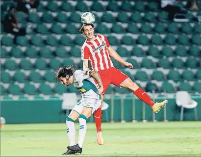  ?? MORELL / EFE ?? Juan Cruz, del Elche, lucha una pelota con Ignasi Miquel, del Girona