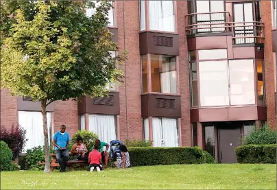  ?? CP PHOTO ?? People relax on the grounds of Cornwall’s Nav Centre, which is temporaril­y housing U.S. asylum seekers, Monday.