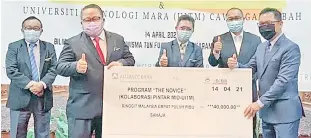  ??  ?? Ministry of Industrial Developmen­t permanent secretary Thomas Logijin (left) presenting a mock cheque for RM40,000 to UiTM Sabah rector Associate Professor Datuk Dr Abdul Kadir Rosline. Also seen is Joachim (centre).