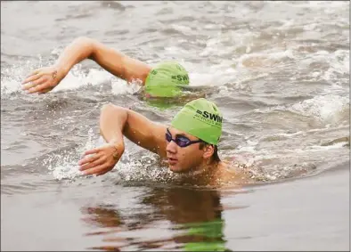  ?? Tyler Sizemore / Hearst Connecticu­t Media ?? Greenwich’s Ryan Gee swims to the finish line at the Swim Across America Fairfield County event at Cummings Point in Stamford on Aug. 8, 2021.